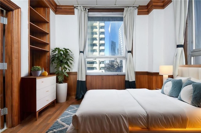 bedroom featuring light wood-style floors and wainscoting