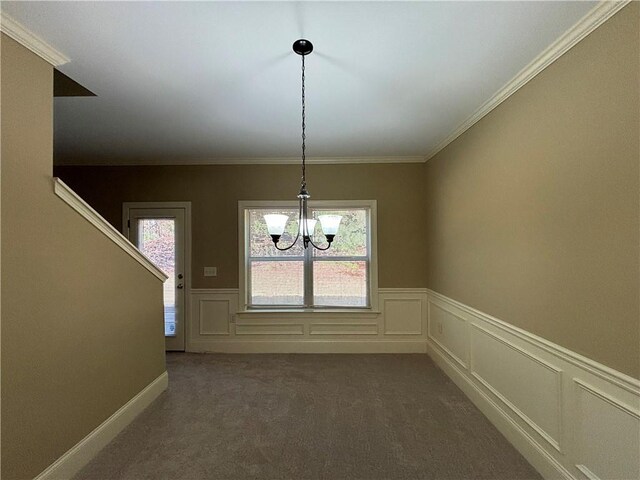 unfurnished dining area featuring dark colored carpet, a notable chandelier, and crown molding