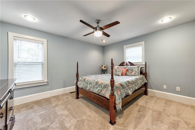 carpeted bedroom with multiple windows and ceiling fan