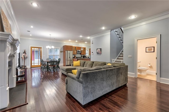 living room with ornamental molding, dark hardwood / wood-style floors, and an inviting chandelier