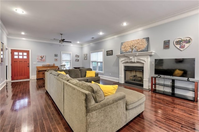 living room featuring dark hardwood / wood-style flooring, ornamental molding, and ceiling fan