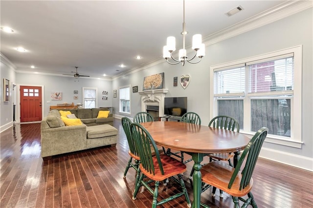 dining space featuring crown molding, ceiling fan with notable chandelier, and dark hardwood / wood-style flooring