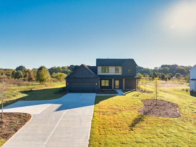 view of front of property with concrete driveway, a front lawn, board and batten siding, and an attached garage