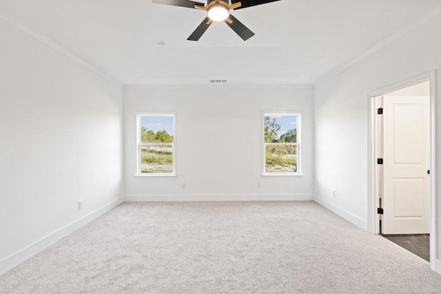 unfurnished room with light colored carpet, a tray ceiling, visible vents, and baseboards