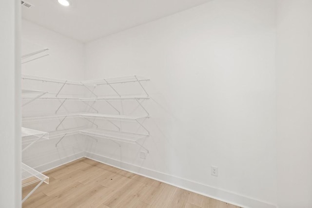 spacious closet with light wood-style flooring and visible vents