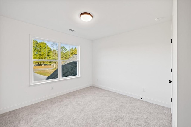 carpeted spare room featuring visible vents and baseboards