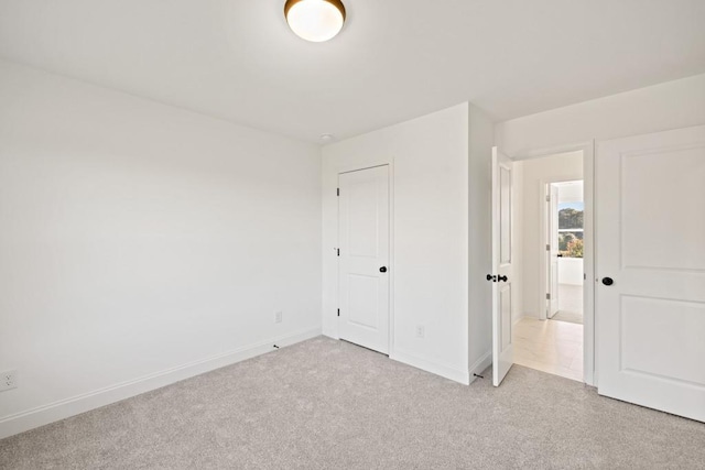 unfurnished bedroom with light carpet and baseboards