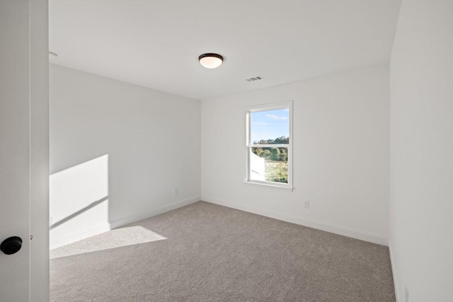 carpeted spare room featuring visible vents and baseboards