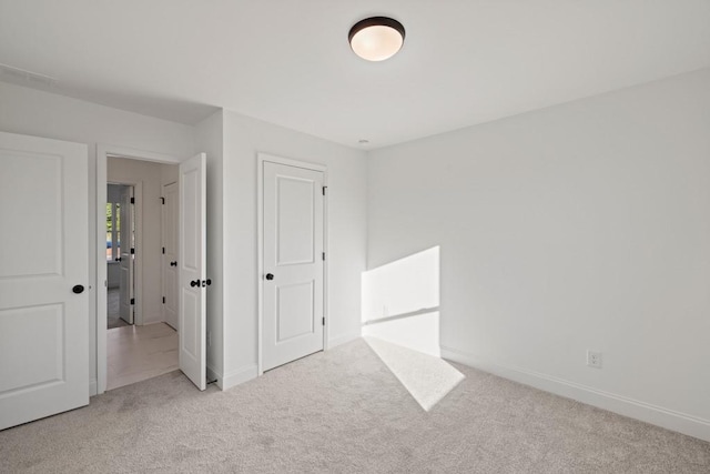 unfurnished bedroom featuring carpet floors and baseboards