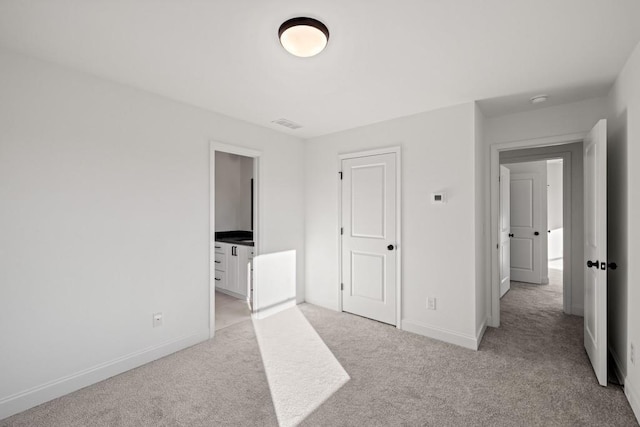 unfurnished bedroom with light carpet and baseboards