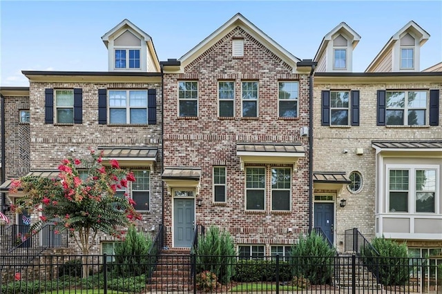 1829 Hislop Ln, Chamblee, GA 30345 - townhome / multi-family property featuring a fenced front yard, brick siding, and a standing seam roof
