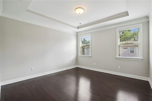 unfurnished room featuring baseboards, crown molding, a tray ceiling, and dark wood-style flooring