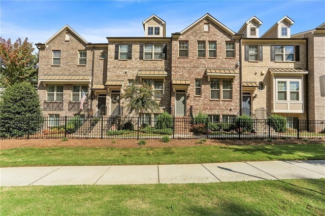 townhome / multi-family property featuring brick siding and fence