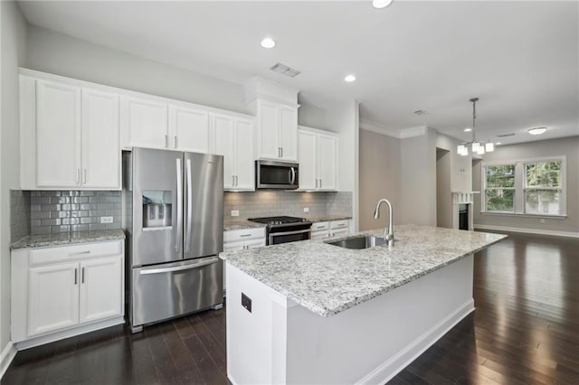 kitchen featuring a sink, a center island with sink, stainless steel appliances, white cabinetry, and dark wood-style flooring