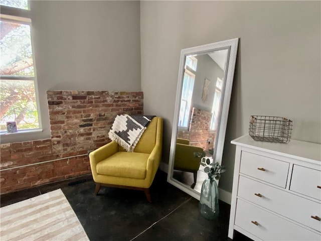 living area featuring brick wall