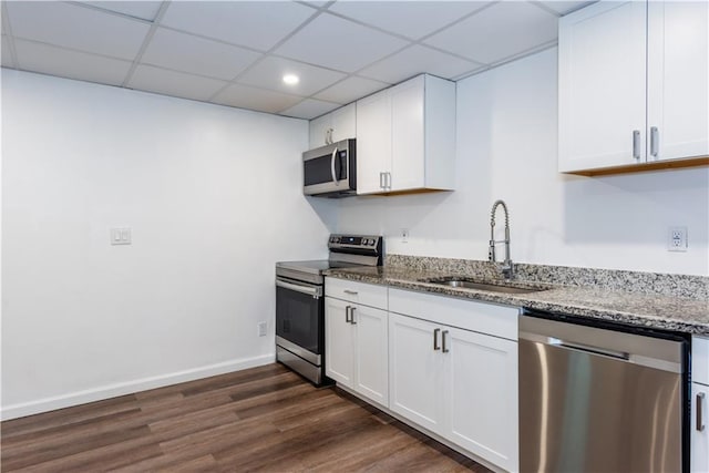 3336 Forrest Hills Dr, Hapeville, GA 30354 - kitchen with appliances with stainless steel finishes, light stone counters, dark wood-style flooring, white cabinets, and a drop ceiling