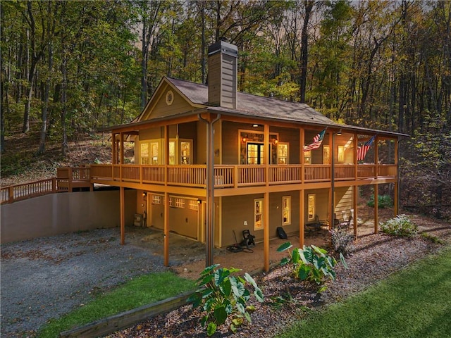 back of house featuring a garage and a wooden deck