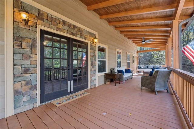 wooden terrace featuring an outdoor living space, french doors, ceiling fan, and a porch