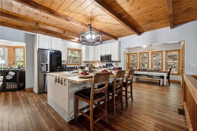 kitchen featuring appliances with stainless steel finishes, dark hardwood / wood-style flooring, white cabinetry, and plenty of natural light