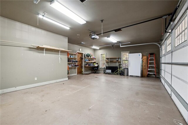 garage featuring white fridge and a garage door opener