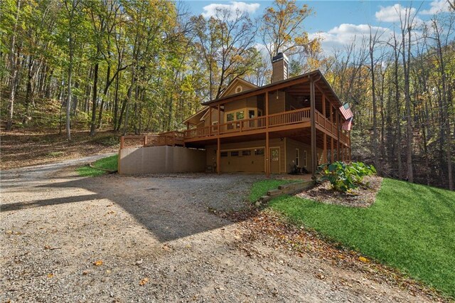 back of house with a garage and a wooden deck