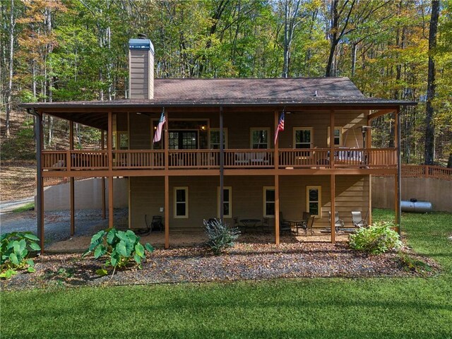 rear view of house with a patio area, a yard, and a deck