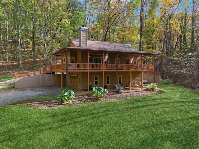 rear view of house featuring a yard and a deck