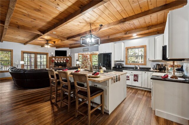 kitchen featuring black fridge, white cabinetry, plenty of natural light, and a kitchen island