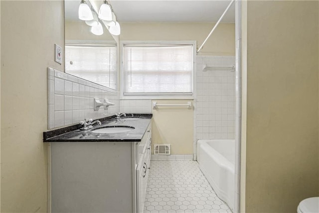 bathroom with vanity, tile walls, and toilet