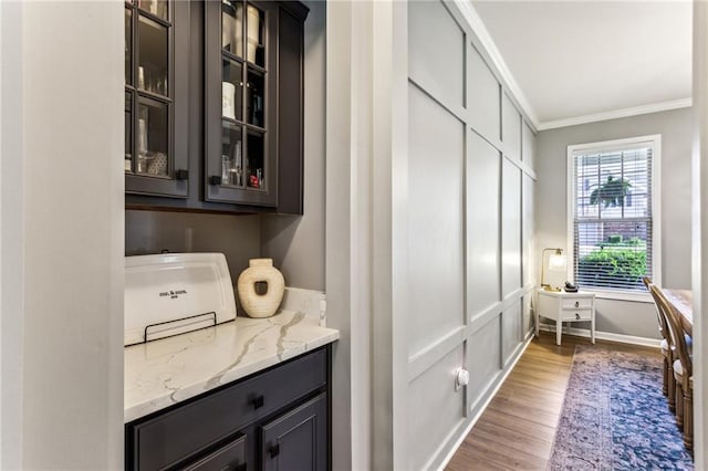 bar with baseboards, ornamental molding, and wood finished floors