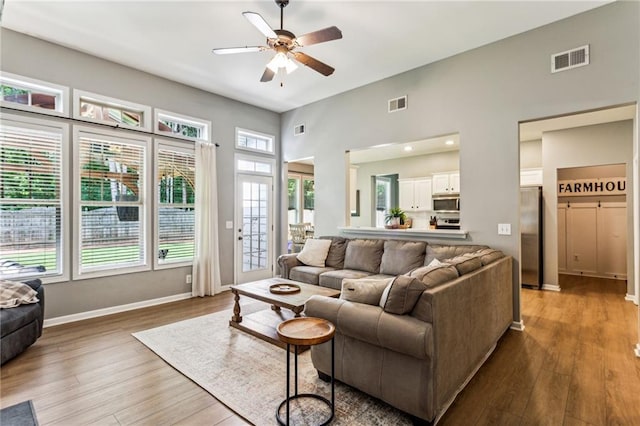 living area with a ceiling fan, wood finished floors, and visible vents