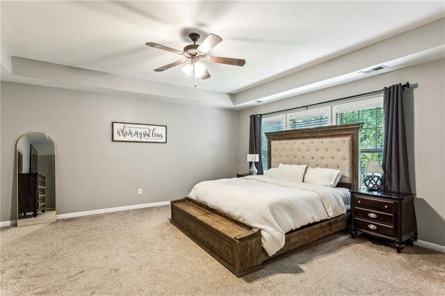 carpeted bedroom featuring baseboards, arched walkways, ceiling fan, and visible vents