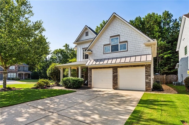 view of front of home featuring a garage, a front lawn, fence, a standing seam roof, and concrete driveway