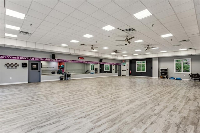 misc room featuring a paneled ceiling, baseboards, visible vents, and wood finished floors
