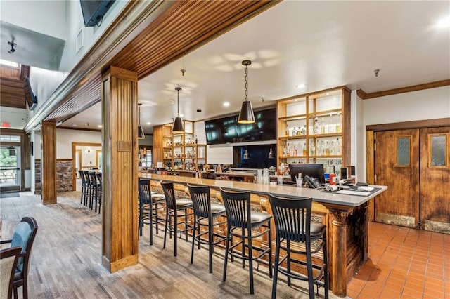 bar featuring crown molding, hanging light fixtures, decorative columns, and recessed lighting