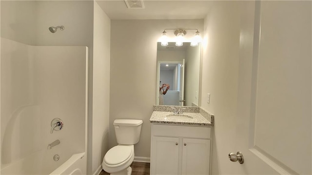 full bathroom with visible vents, toilet,  shower combination, baseboards, and vanity