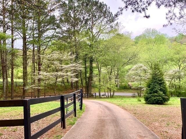 view of community featuring fence and a view of trees