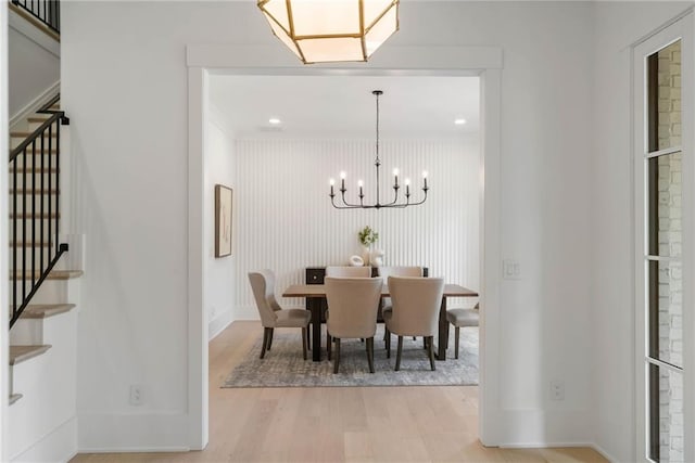 dining area with light wood-type flooring and a chandelier