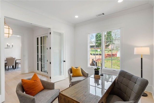 interior space featuring a chandelier, crown molding, and french doors