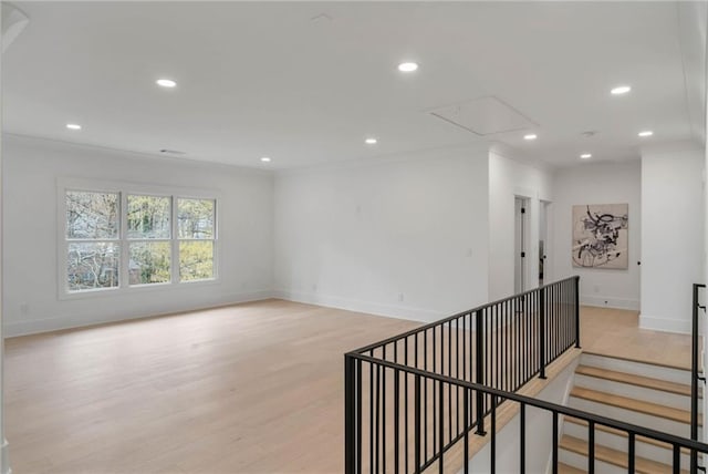 empty room featuring crown molding and light hardwood / wood-style floors