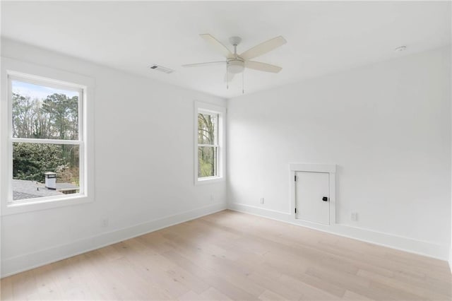 spare room featuring ceiling fan, a healthy amount of sunlight, and light hardwood / wood-style floors