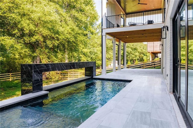 view of swimming pool with ceiling fan and a patio