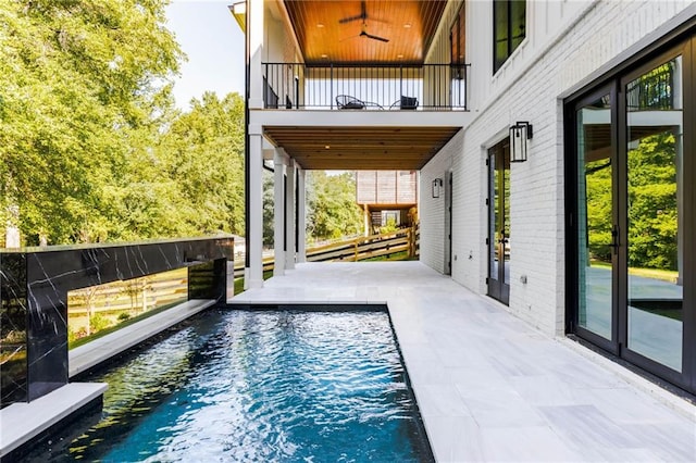 view of pool featuring ceiling fan and a patio area