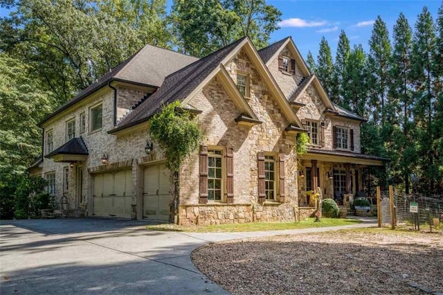 3809 Wieuca Rd NE, Atlanta, GA 30342 - view of front of house with stone siding, concrete driveway, covered porch, and roof with shingles