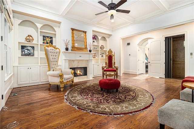 3809 Wieuca Rd NE, Atlanta, GA 30342 - living area with built in shelves, a fireplace, a ceiling fan, arched walkways, and wood finished floors