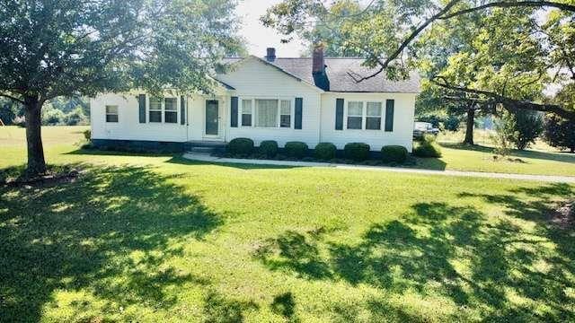 single story home featuring a front lawn