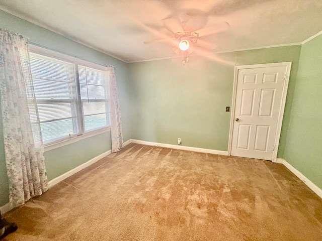 carpeted spare room featuring ceiling fan