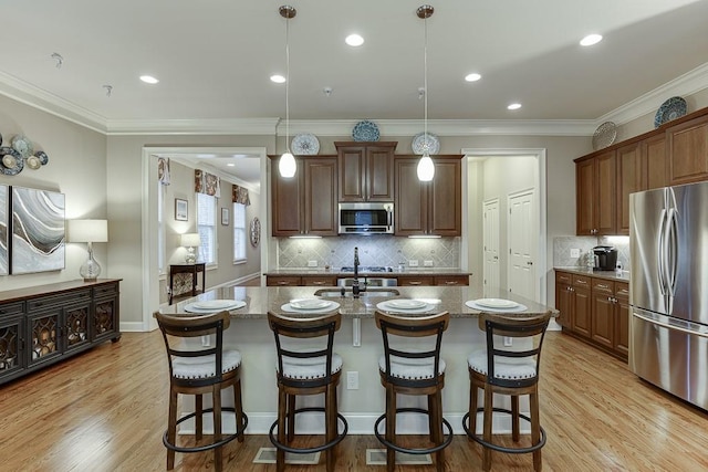 kitchen with a kitchen bar, stone counters, light wood-type flooring, and appliances with stainless steel finishes