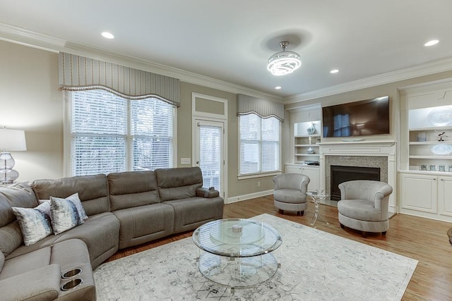 living room featuring a fireplace, wood finished floors, baseboards, and ornamental molding