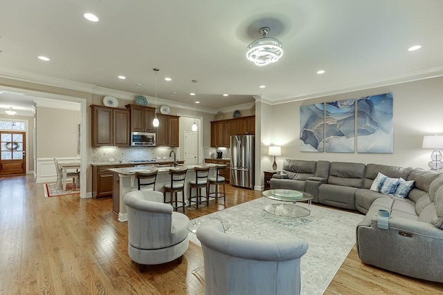 living room with recessed lighting, wood finished floors, and ornamental molding